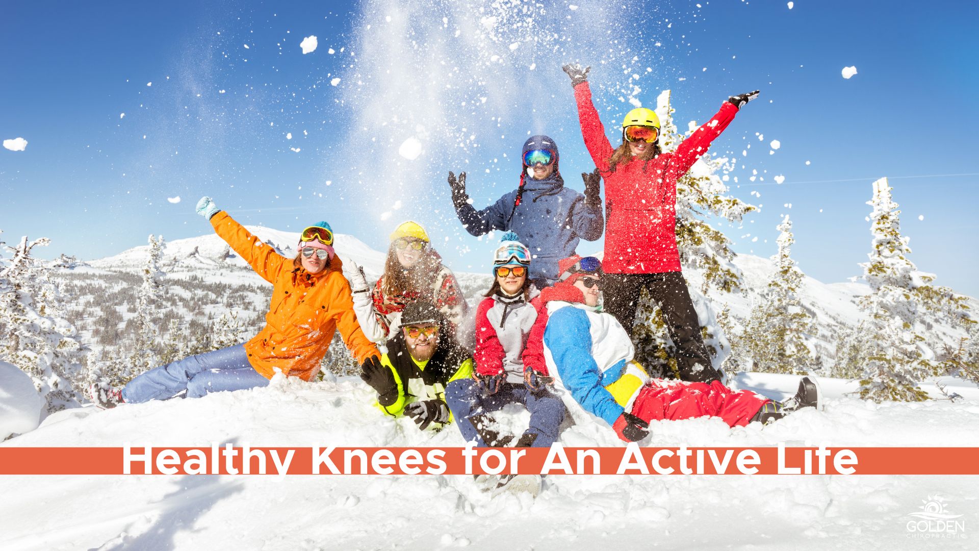 Group of people in snow gear playing happily in the snow