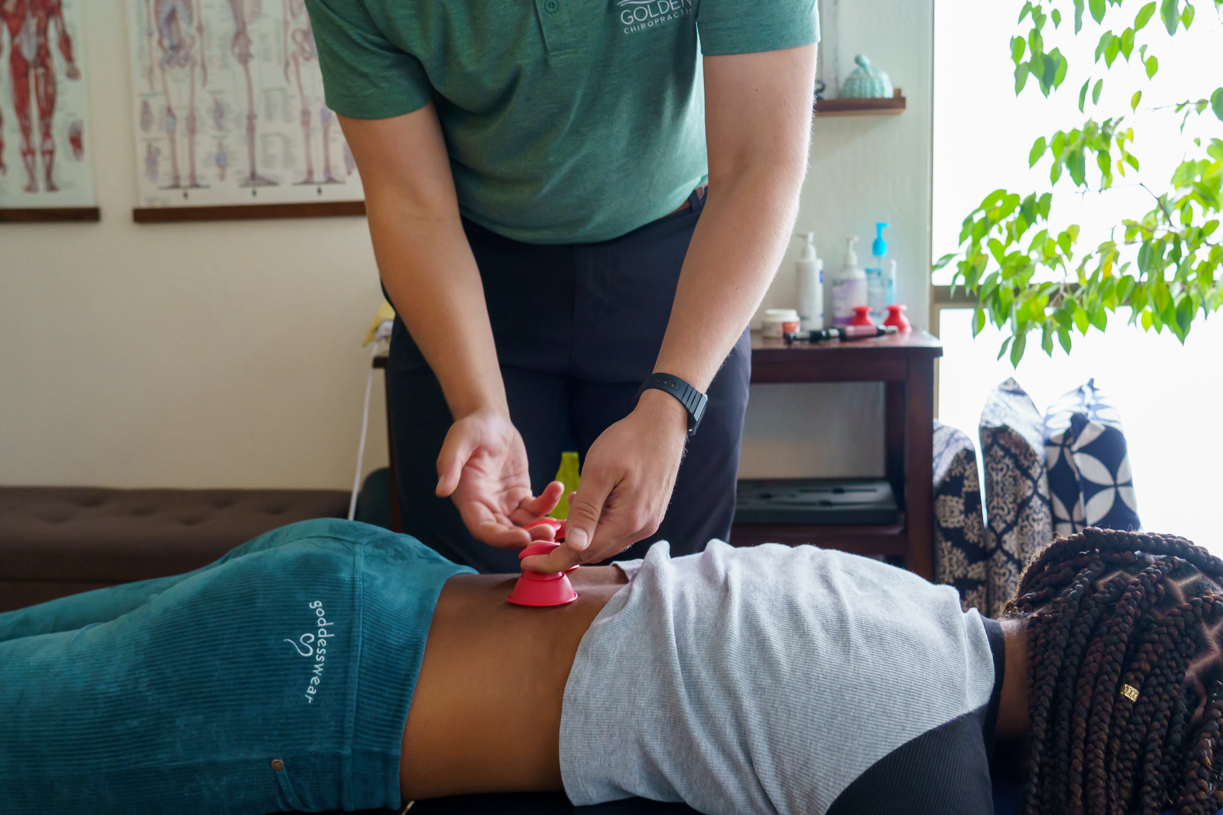 Dr. Joe applying rockpods cupping to relieve a female patient's lower back pain