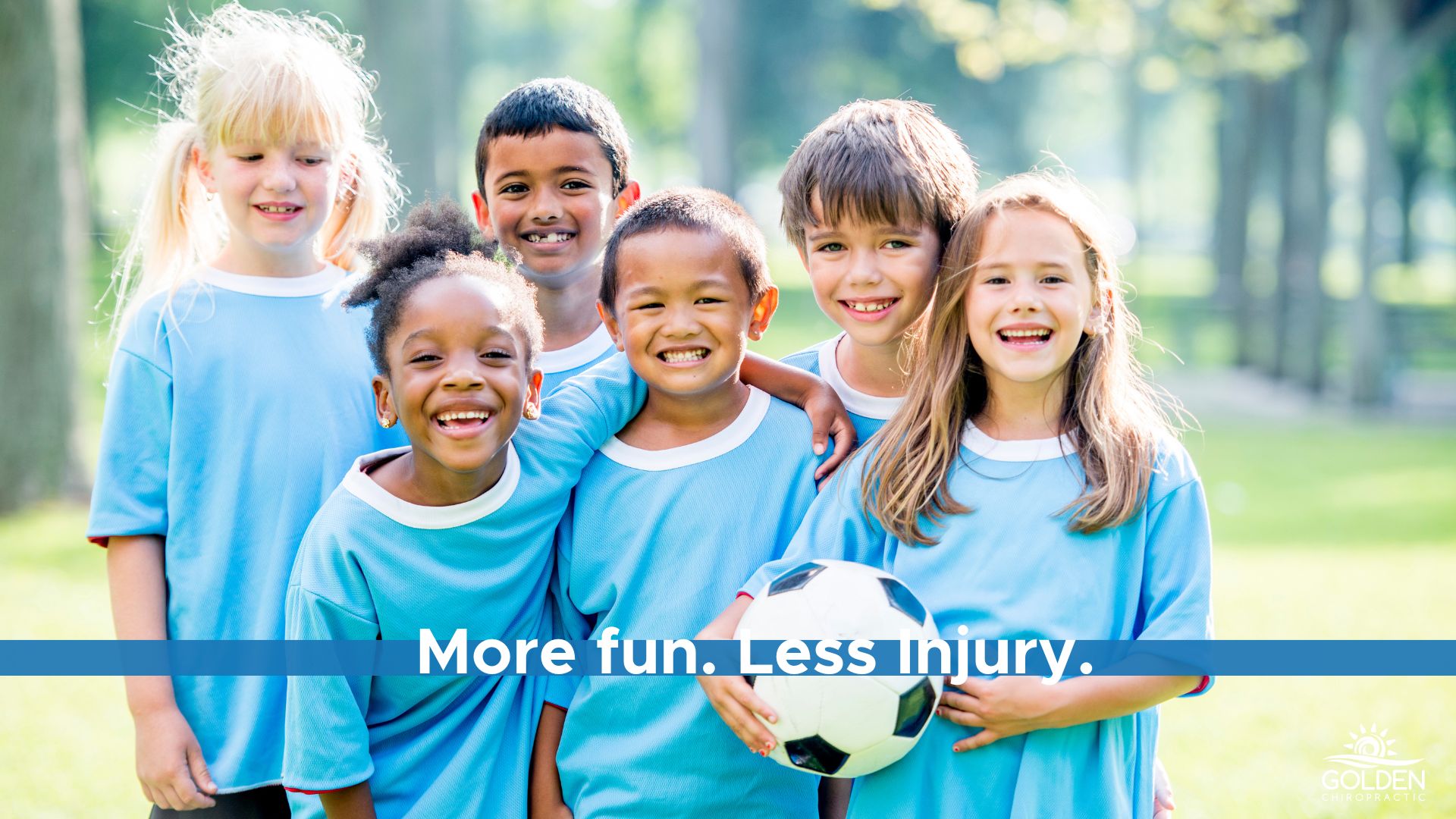 Mixed gender group of kids in soccer uniforms smiling, holding a soccer ball